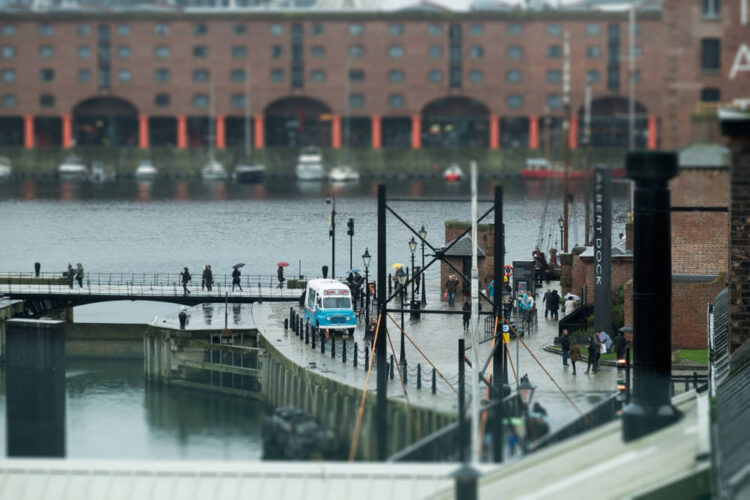 A vintage ice-cream van at the Albert Docks on a rainy, February day, with lots of people walking past with umbrellas up