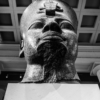 Looking up at a colossal granite head of a pharaoh.