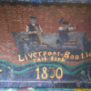 Part of the timeline mural in Marsh Lane Time Tunnel showing two construction workers building a rail track, with the caption 'Liverpool-Bootle rail link 1850'