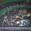 one of the flowers painted on the wall has a crude 'knob' (penis and testicles) scrawled next to it