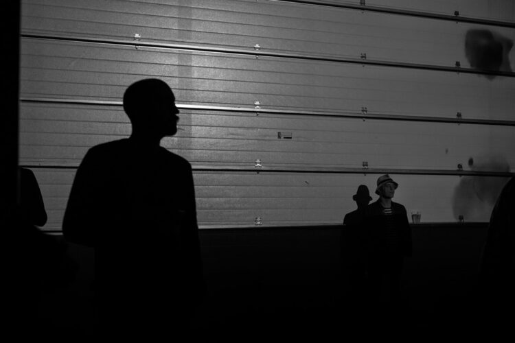 Silhouettes of two people in a warehouse listening to music