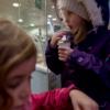 The two girls eating shots of liquid chocolate out of small containers