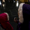 The two girls looking down the street, hoods up as it's raining