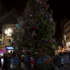 The two girls standing in front of a large Christmas tree (a proper tree, this time). The tree is covered in lights and over-sized paperchains.