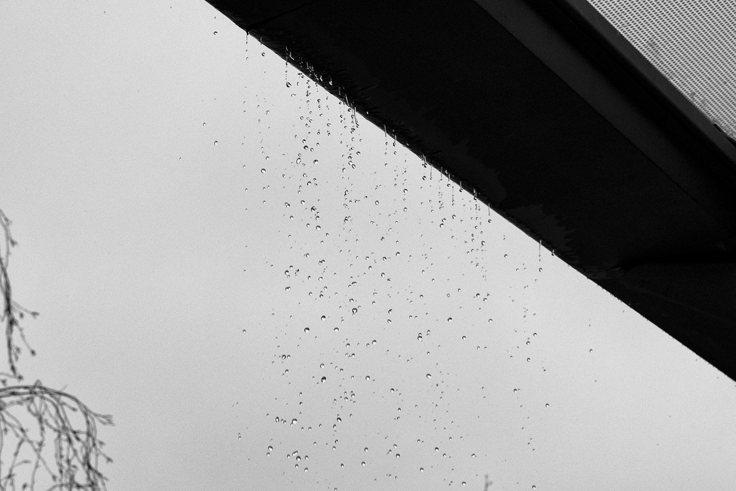 Water droplets falling off the edge of a roof shelter