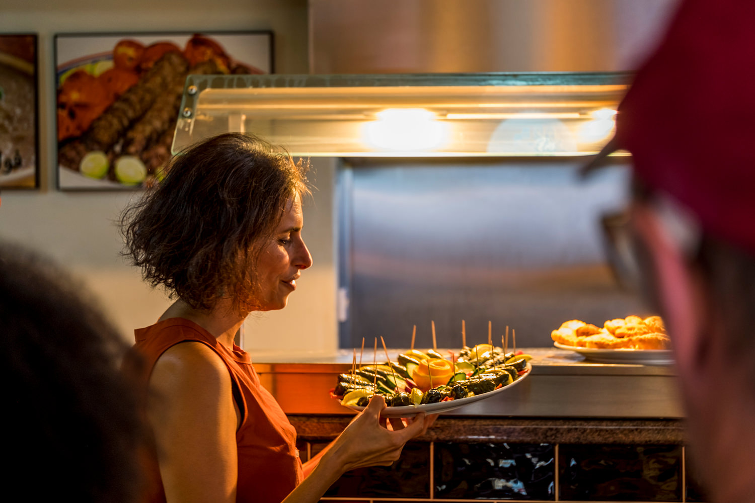 A woman holding a plate of Lebanese finger food.