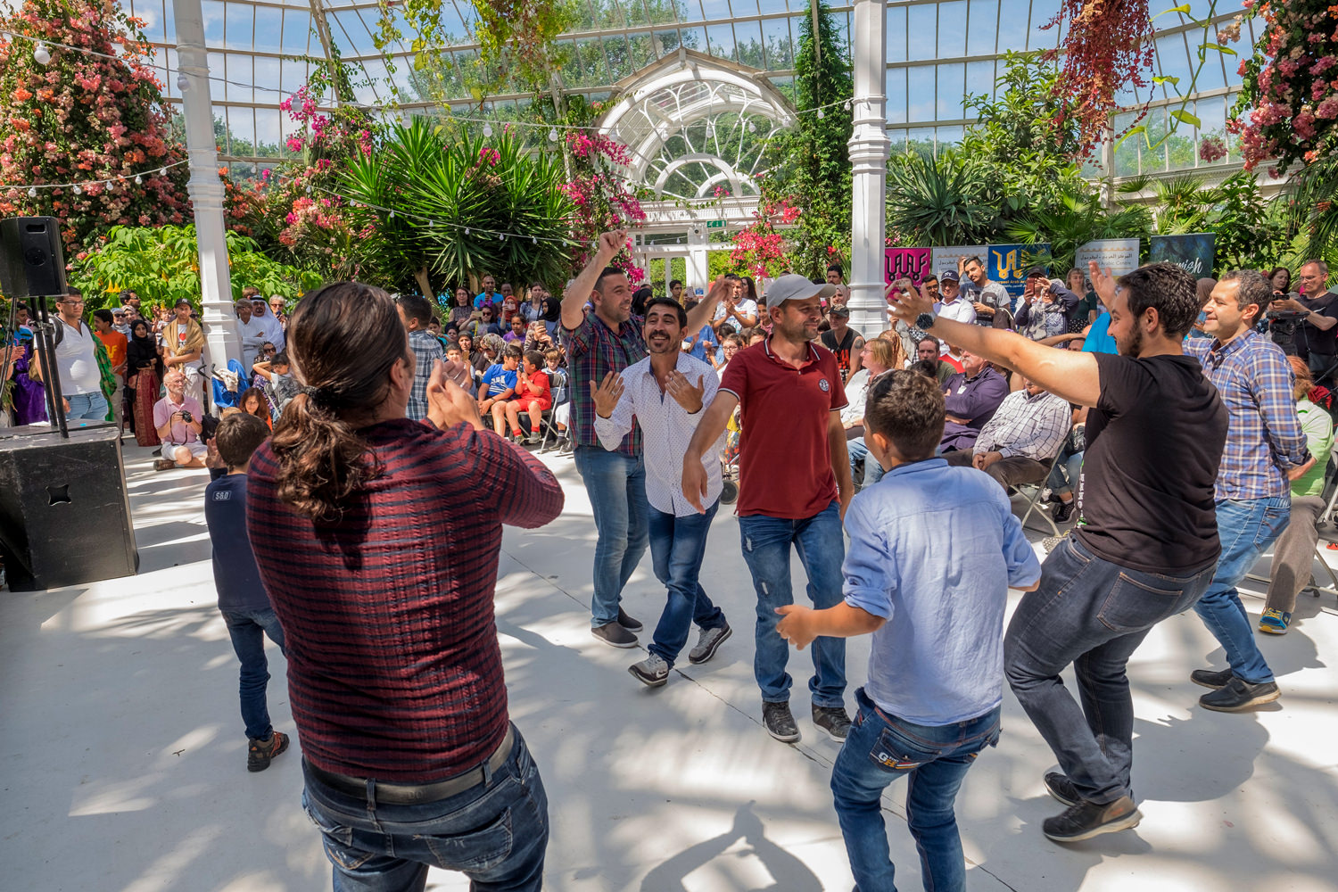 A group of men are dancing in the Palm House.